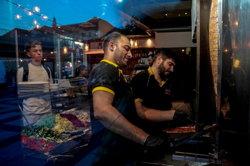 Turkish doner cooks prepare doner kebabs for customers in a doner kebab restaurant in Berlin, Germany, Wednesday, Sept. 18, 2024. (AP Photo/Ebrahim Noroozi)