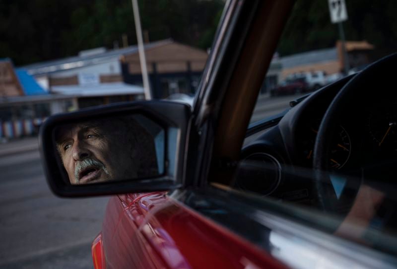 Robert Greenamyer, a full-time resident of Ruidoso, N.M., waits in his car for re-entry into the fire-ravaged village, Monday, June 24, 2024. (Chancey Bush/The Albuquerque Journal via AP)