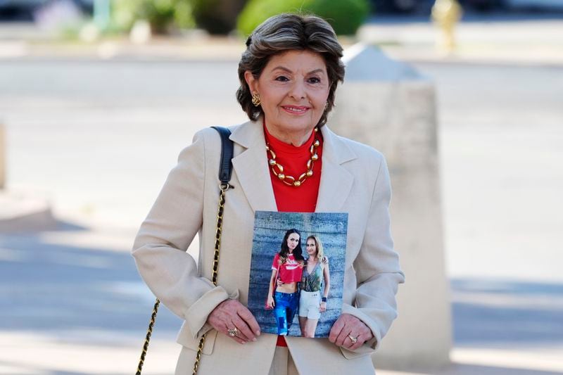 Attorney Gloria Allred arrives at the courthouse for actor Alec Baldwin's involuntary manslaughter trial while holding a photograph of "Rust" film cinematographer Halyna Hutchins Thursday, July 11, 2024, in Santa Fe, NM. Allred represents the Ukraine-based parents of Hutchins and a sister of the deceased cinematographer in a civil lawsuit against Baldwin and other "Rust" producers and the film's gun-safety crew. (AP Photo/Ross D. Franklin)