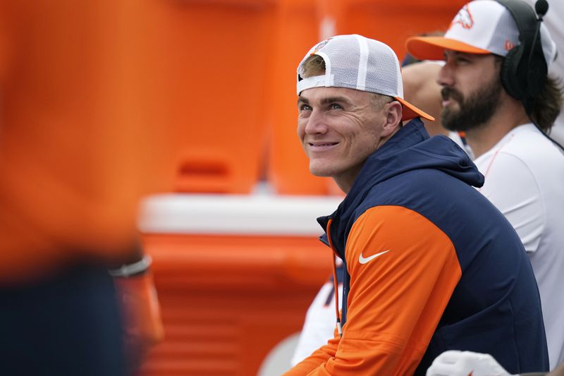 Denver Broncos quarterback Bo Nix smiles as he sits on the bench during the second half of a preseason NFL football game against the Arizona Cardinals Sunday, Aug. 25, 2024, in Denver. (AP Photo/Jack Dempsey)