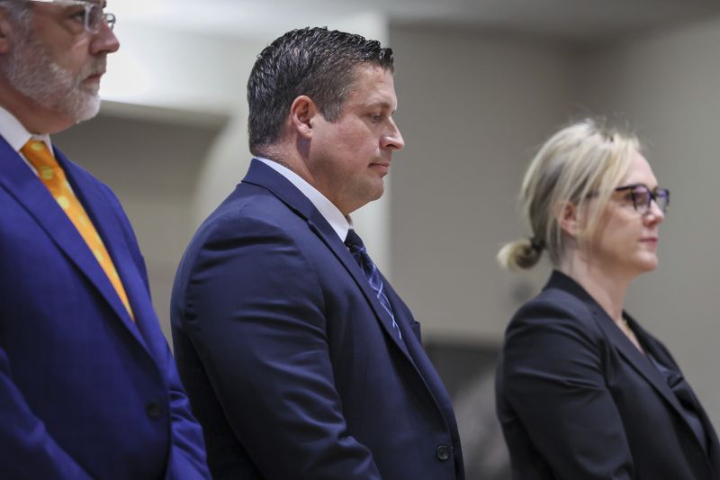 Jeffrey Nelson, flanked by attorneys, stands at the King County Maleng Regional Justice Center in Kent, Wash., on Thursday, June 27, 2024. A jury found the suburban Seattle police officer guilty of murder in the 2019 shooting death of a homeless man outside a convenience store, marking the first conviction under a Washington state law easing prosecution of law enforcement officers for on-duty killings. (Kevin Clark/The Seattle Times via AP)
