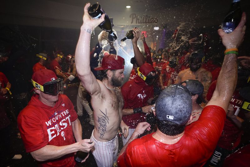 Philadelphia Phillies' Bryce Harper celebrates with teammates after the Phillies won a baseball game against the Chicago Cubs to clinch the NL East title, Monday, Sept. 23, 2024, in Philadelphia. (AP Photo/Matt Slocum)