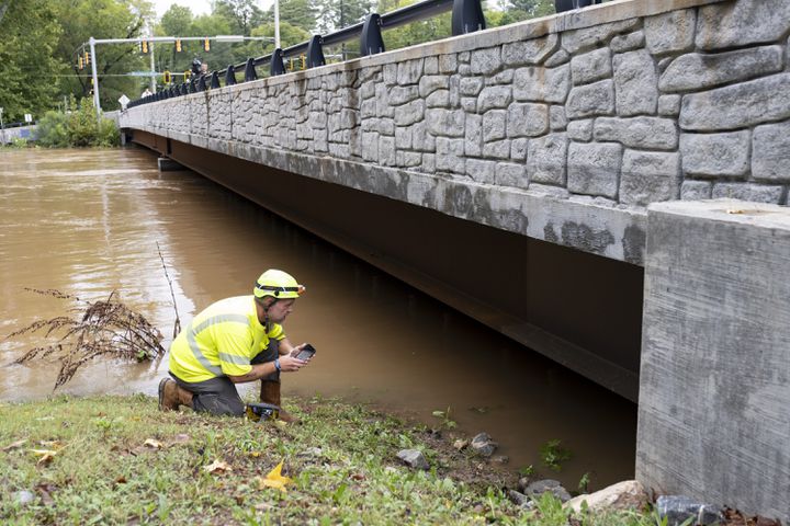 A GDOT bridge inspector checks for damage where Northside Drive NW crosses Peachtree Creek in Atlanta on Friday, Sept. 27, 2024 following a night of heavy rain from Hurricane Helene.   Ben Gray for the Atlanta Journal-Constitution