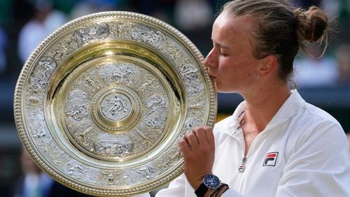 Barbora Krejcikova of the Czech Republic kisses her trophy after defeating Jasmine Paolini of Italy in the women's singles final at the Wimbledon tennis championships in London, Saturday, July 13, 2024. (AP Photo/Kirsty Wigglesworth)