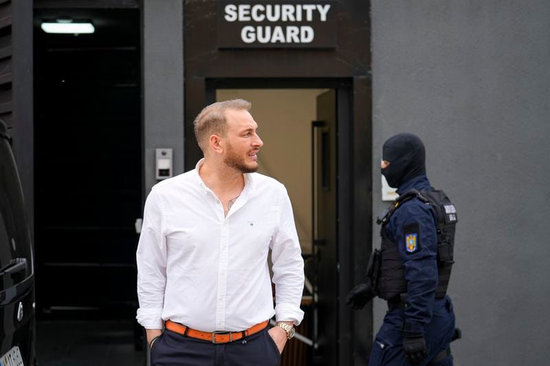 Internet influencer Andrew Tate's lawyer Eugen Vidineac exits the residence of Andrew Tate during an early morning search raid by the police, on the outskirts of Bucharest, Romania, Wednesday, Aug. 21, 2024. (AP Photo/ Vadim Ghirda)