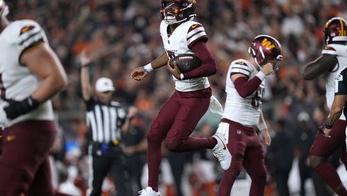 Washington Commanders quarterback Jayden Daniels celebrates after throwing a touchdown pass during the second half of an NFL football game against the Cincinnati Bengals, Monday, Sept. 23, 2024, in Cincinnati. (AP Photo/Carolyn Kaster)