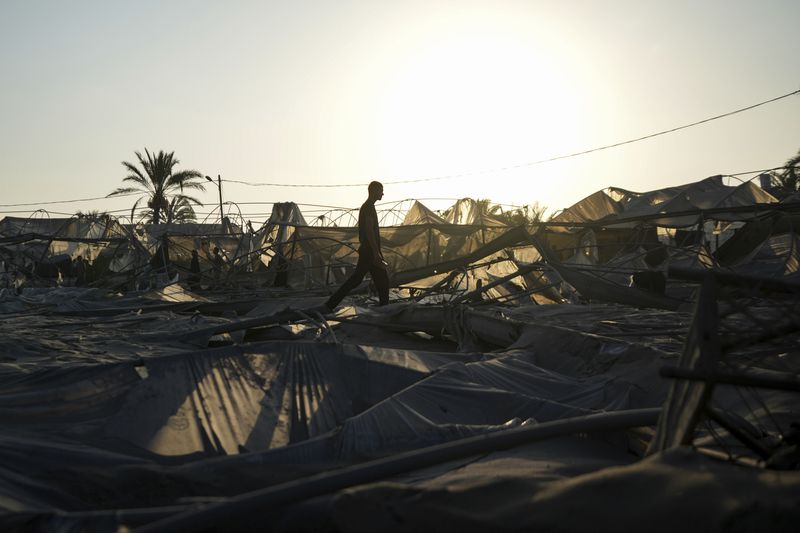 Palestinians look at the destruction after an Israeli airstrike on a crowded tent camp housing Palestinians displaced by the war in Muwasi, Gaza Strip, Tuesday, Sept. 10, 2024. An Israeli strike killed at least 40 people and wounded 60 others early Tuesday, Palestinian officials said. Israel said it targeted "significant" Hamas militants, allegations denied by the militant group. (AP Photo/Abdel Kareem Hana)