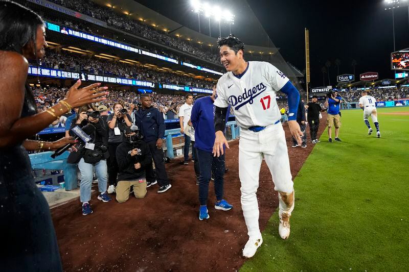 Los Angeles designated hitter Shohei Ohtani (17) reacts after teammates poured drinks on his head after hitting a grand slam during the eighth inning of a baseball game against the Tampa Bay Rays in Los Angeles, Friday, Aug. 23, 2024. Will Smith, Tommy Edman, and Max Muncy also scored. The Dodgers won 7-3. (AP Photo/Ashley Landis)