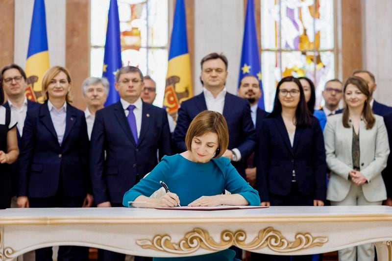 In this image released by Moldova's President, Moldova's President Maia Sandu signs the decree on initiating Moldova's EU accession negotiations in Chisinau, Moldova, Friday, June 21, 2024. The European Union agreed Friday to start membership negotiations with embattled Ukraine and Moldova, another step in the nations' long journey to move closer to the West and mute Russia's influence. (Moldovan Presidency via AP)