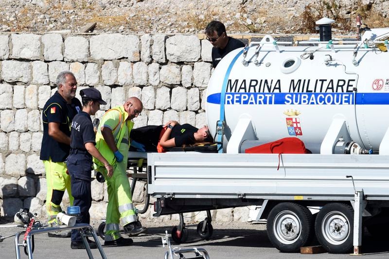 Italian Navy scuba divers set a hyperbaric chamber as they work at the scene of the search for a missing boat, in Porticello, southern Italy, Thursday, Aug. 22, 2024. Rescue teams and divers returned to the site of a storm-sunken super yacht to search for one person, who are believed to be still trapped in the hull 50 meters (164-feet) underwater. (AP Photo/Salvatore Cavalli)