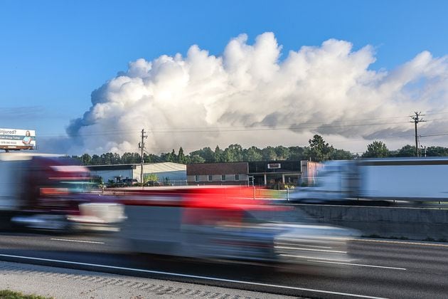 The large plume of smoke from a  chemical plant fire on Sunday is still visible from I-20 eastbound near West Avenue in Conyers on Monday morning. (John Spink / AJC)