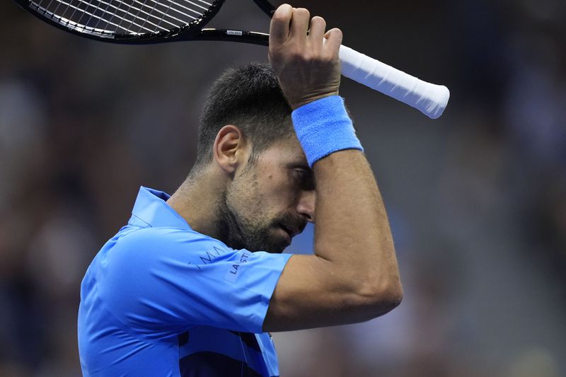 Novak Djokovic, of Serbia, wipes his face against =Alexei Popyrin, of Australia, during a third round match of the U.S. Open tennis championships, Friday, Aug. 30, 2024, in New York. (AP Photo/Julia Nikhinson)