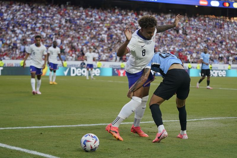 Weston McKennie, left, of the United States, and Uruguay's Maximiliano Araujo, right, battle for the ball during a Copa America Group C soccer match, Monday, July 1, 2024, in Kansas City, Mo. (AP Photo/Ed Zurga)