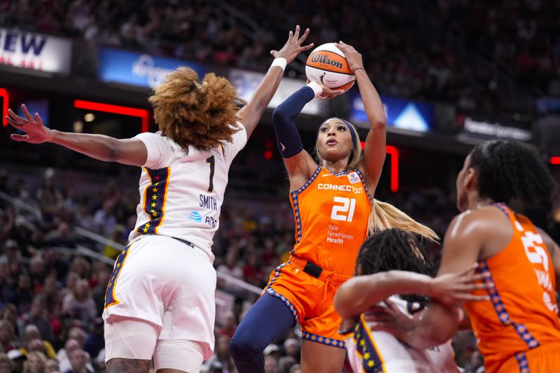 Connecticut Sun guard DiJonai Carrington (21) shoots over Indiana Fever forward NaLyssa Smith (1) in the first half of a WNBA basketball game in Indianapolis, Wednesday, Aug. 28, 2024. (AP Photo/Michael Conroy)