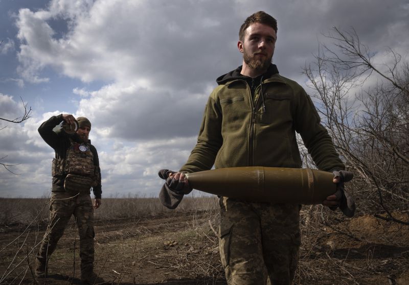 FILE - Ukrainian soldiers carry shells to fire at Russian positions on the front line, near the city of Bakhmut, in Ukraine's Donetsk region, on March 25, 2024. Russia has made incremental but steady advances in Donetsk, and Putin has declared that Moscow isn’t seeking quick gains and would stick to the current strategy of advancing slowly. (AP Photo/Efrem Lukatsky, File)