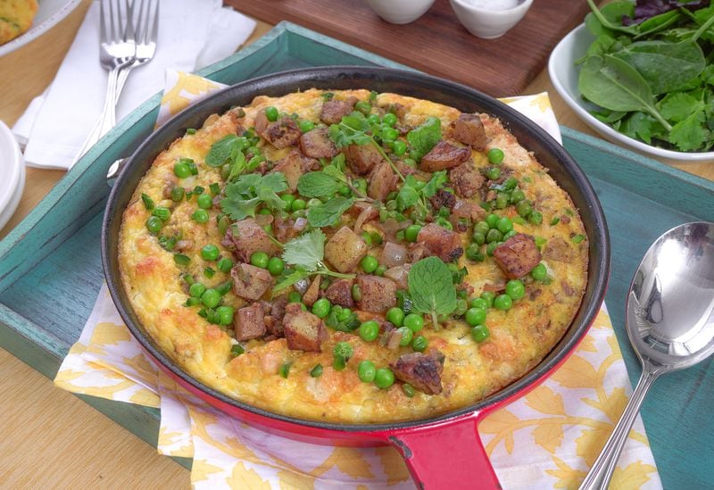 This recipe showcases the exceptionally fragrant flavors and ingredients of Indian samosas. Potatoes and onions are cooked and crisped with garam masala then mixed with spring peas, fresh ginger and bits of jalapeno to form the frittata filling. Fresh cilantro and mint are sprinkled on top once the frittata is baked and cooled. (Chadwick Boyd for The Atlanta Journal-Constitution)