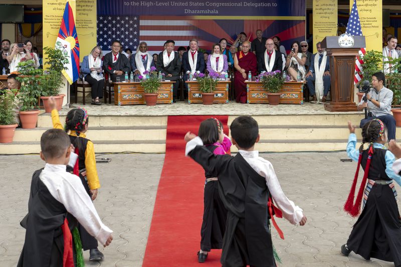Republican Rep. Michael McCaul and Democratic former House Speaker Nancy Pelosi sit on a stage in the front row to watch Tibetan children perform at a public event during which they were felicitated by the President of the Central Tibetan Administration and other officials at the Tsuglakhang temple in Dharamshala, India, Wednesday, June 19, 2024. (AP Photo/Ashwini Bhatia)