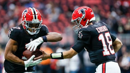 Falcons quarterback Kirk Cousins (18) hands the ball to running back Bijan Robinson (7) during warm-ups before the Falcons face the New Orleans Saints on Sunday, Sept. 29, at Mercedes-Benz Stadium in Atlanta. 
(Miguel Martinez/ AJC)