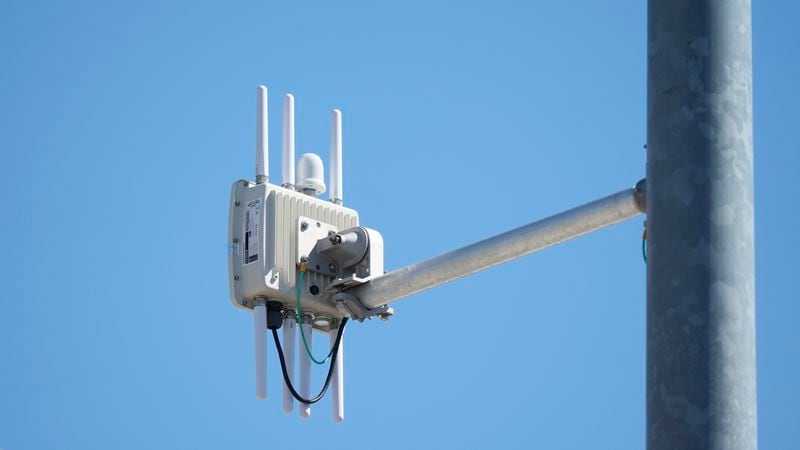 A radio transmitter hangs from a traffic light pole as it transmits to equipped commuter buses on Redwood Road, part of an effort to improve safety and efficiency by allowing cars to communicate with the roadside infrastructure and one another, Friday, Sept. 6, 2024, near Salt Lake City. (AP Photo/Rick Bowmer)