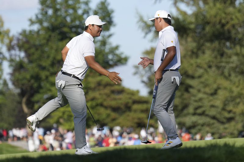 International team member Si Woo Kim, right, of South Korea, celebrates with partner Tom Kim, left, also of South Korea, after a birdie putt on the fifth hole during a fourth-round foursomes match at the Presidents Cup golf tournament at Royal Montreal Golf Club in Montreal, Saturday, Sept. 28, 2024. (NathanDenette/The Canadian Press via AP)