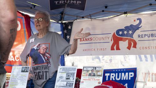 Charlotte Horvath, treasurer for the Banks County Republican Party, works a booth at the Labor Day Festival in Homer with political hats, signs and flags available for donations.  Banks County is a Republican stronghold, where Donald Trump won nearly 89% of the vote in 2020. Turnout is the big concern for Republican officials there. “We’re going to win this county," said Brian Parker, the county's Republican chair, "but we need as many votes here as we can get to take away from all the votes in Fulton County.” (Ben Gray / Ben@BenGray.com)