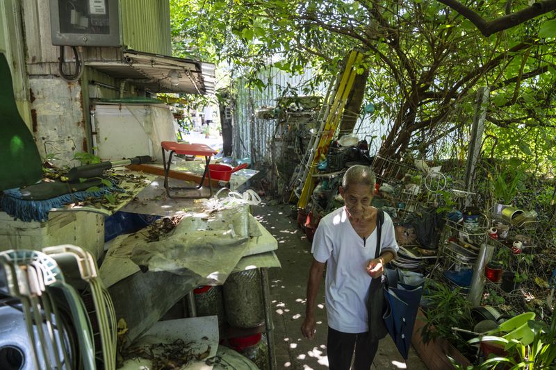 A villager walks through the Cha Kwo Ling village in east Kowloon, Hong Kong, Sunday, Aug. 25, 2024. (AP Photo/Chan Long Hei)