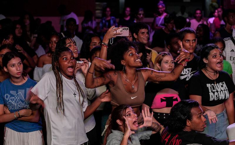 Teenagers react as they watch dancers participate in a K-pop contest at a cultural house in Havana, Cuba, Saturday, Sept. 7, 2024. (AP Photo/Ramon Espinosa)