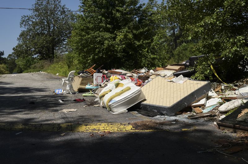 An area on the grounds of Brannon Hill Condominiums that has become a dumping ground for trash on Tuesday, May 10, 2022.  (Natrice Miller / natrice.miller@ajc.com)