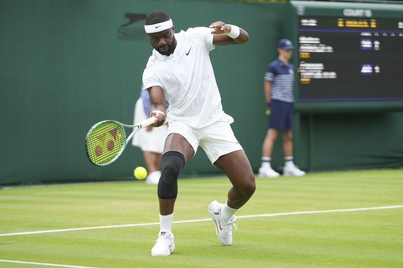 Frances Tiafoe of the United States plays a forehand return to Matteo Arnaldi of Italy during his first round match of the Wimbledon tennis championships in London, Monday, July 1, 2024. (AP Photo/Mosa'ab Elshamy)