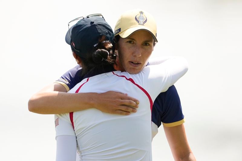 Europe's Carlota Ciganda, right, concedes to United States' Rose Zhang on the 14th green during a Solheim Cup golf tournament singles match at the Robert Trent Jones Golf Club, Sunday, Sept. 15, 2024, in Gainesville, Va. (AP Photo/Matt York)