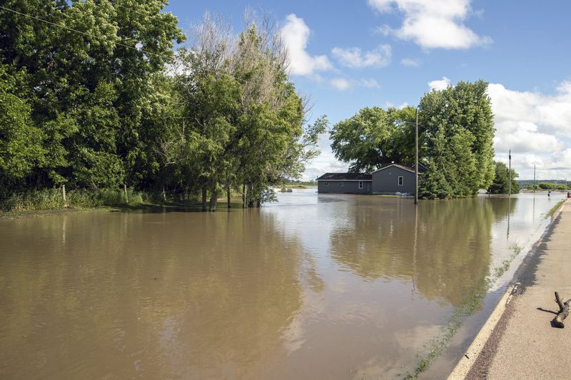 Floodwaters surround a home in Canton, S.D., Saturday, June 22, 2024, after days of heavy rain led to flooding in the area. (AP Photo/Josh Jurgens)