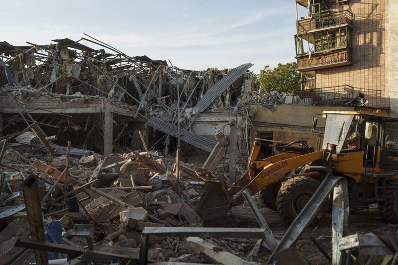 A tractor clears the rubble after a Russian strike on the Sapphire hotel in Kramatorsk, Donetsk region, Ukraine, on Sunday, Aug. 25, 2024. (AP Photo/Evgeniy Maloletka)