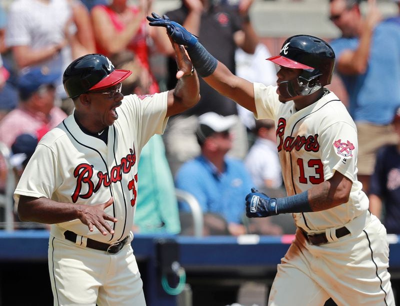 Ronald Acuna Jr. gets five from Ron Washington rounding third base while hitting a 2-run homer to take a 4-2 lead over the Milwaukee Brewers during the second inning in a MLB baseball game on Sunday, August 12, 2018, in Atlanta.  Curtis Compton/ccompton@ajc.com