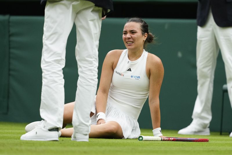 Elena-Gabriela Ruse of Romania reacts after falling during her first round match against Elena Rybakina of Kazakhstan at the Wimbledon tennis championships in London, Tuesday, July 2, 2024. (AP Photo/Mosa'ab Elshamy)