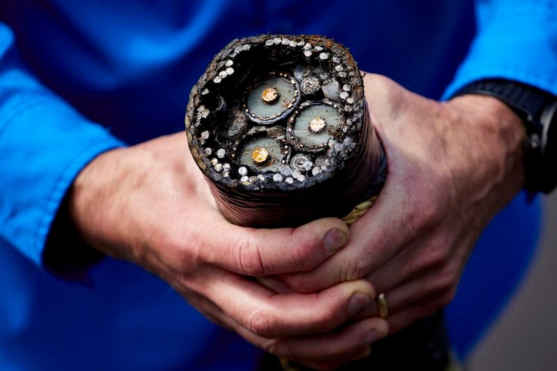 Burke Hales, chief scientist for the PacWave wave energy test site overseen by Oregon State University, shows the electric cables that are buried under the seabed in Newport, Ore., Friday, Aug. 23, 2024. (AP Photo/Craig Mitchelldyer)