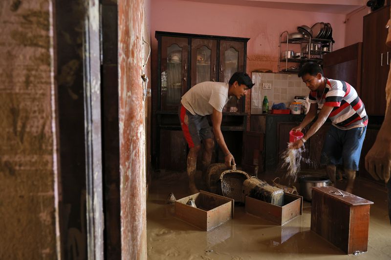 Residents clean their water-logged kitchen in Kathmandu, Nepal, Monday, Sept. 30, 2024 after a flood caused by heavy rains. (AP Photo/Gopen Rai)