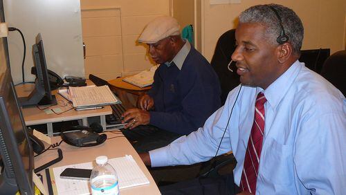 Glenn Randall (l) and Kevin Wright answer calls at the Homework Hotline, a free community service provided by the Atlanta Public School system. The 5-member team fields questions from students around the country.