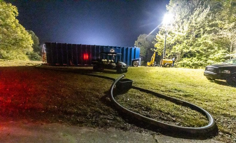 Containers and trucks were staged on VFW Drive near a residential area not far from BioLab. The plume of smoke rising from BioLab continued on Thursday, Oct. 3, 2024 in Conyers. A Sunday fire at the chemical plant in Conyers has had agencies monitoring the air quality since then as crews try to neutralize the site. Rockdale County officials said that the plume is changing colors as workers remove debris. GEMA has advised anyone who notices a chlorine odor in the air to limit their time outdoors. (John Spink/AJC)