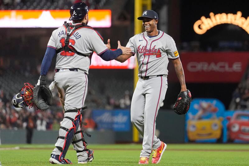 Atlanta Braves catcher Travis d'Arnaud, left, celebrates with pitcher Raisel Iglesias after the Braves defeated the San Francisco Giants in 10 innings of a baseball game in San Francisco, Tuesday, Aug. 13, 2024. (AP Photo/Jeff Chiu)