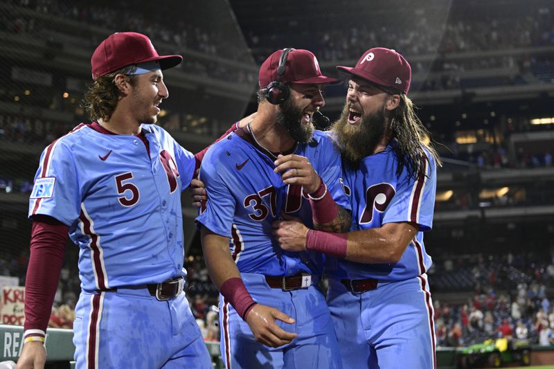 Philadelphia Phillies' Weston Wilson, center, celebrates after he was doused by teammates Brandon Marsh, right, and Bryson Stott after a victory over the Washington Nationals in a baseball game, Thursday, Aug. 15, 2024, in Philadelphia. (AP Photo/Derik Hamilton)