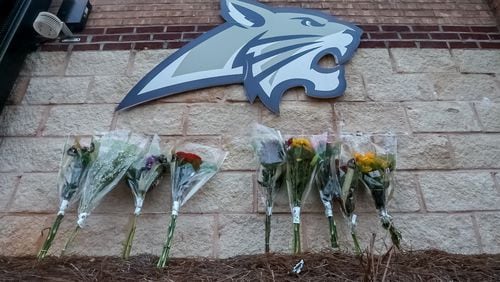 Flowers are lain at the foot of the welcome sign to Apalachee High School for a makeshift memorial Thursday morning, a day after two students and two teachers were gunned down. Nine others were injured.