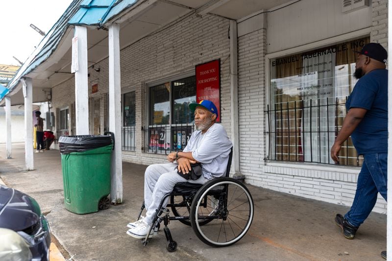 Ricky Gibbs, 67, relaxes outside Lotto Grocery on Glenwood Road near its intersection with Columbia Drive in southern DeKalb County on Wednesday, Sept. 25, 2024. (Arvin Temkar / AJC)