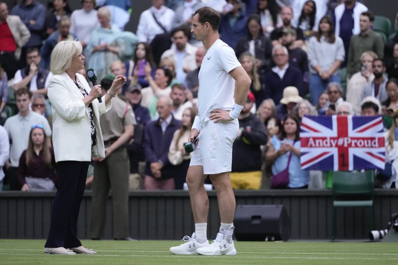 Britain's Andy Murray talks with Sue Barker following his first round doubles match with this brother Jamie against Australia's John Peers and Ricky Hijikata at the Wimbledon tennis championships in London, Thursday, July 4, 2024. (AP Photo/Kirsty Wigglesworth)