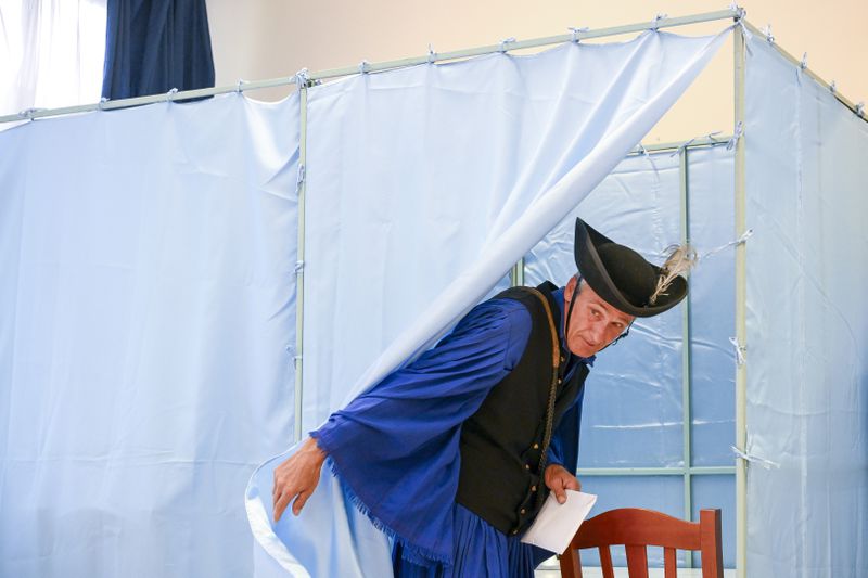 Traditional Hungarian horse-herdsman, so-called csikos, Janos Garai, casts his vote at a polling station during the European Parliament and local elections, in Hortobagy, Hungary, Sunday, June 9, 2024. Voters across the European Union are going to the polls on the final day of voting for the European parliamentary elections to choose their representatives for the next five-year term. (Zsolt Czegledi/MTI via AP)