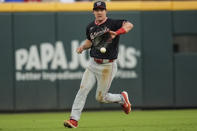 Washington Nationals outfielder Jacob Young (30) fields a ball hit by Atlanta Braves' Ramón Laureano in the second inning of a baseball game, Saturday, Aug. 24, 2024, in Atlanta. (AP Photo/Mike Stewart)