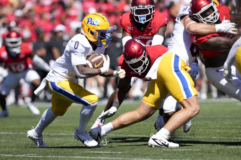 Pittsburgh running back Desmond Reid (0) carries the ball during the first half of an NCAA college football game against Cincinnati, Saturday, Sept. 7, 2024, in Cincinnati. (AP Photo/Jeff Dean)