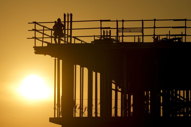 Construction workers start their day as the sun rises on the new Republic Airlines headquarters building in Carmel, Ind., Tuesday, Aug. 27, 2024. (AP Photo/Michael Conroy)