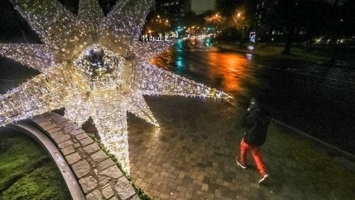 Gerald Stewart walks by a large illuminated holiday display at Peachtree Street and Beverly Road in Midtown Atlanta.