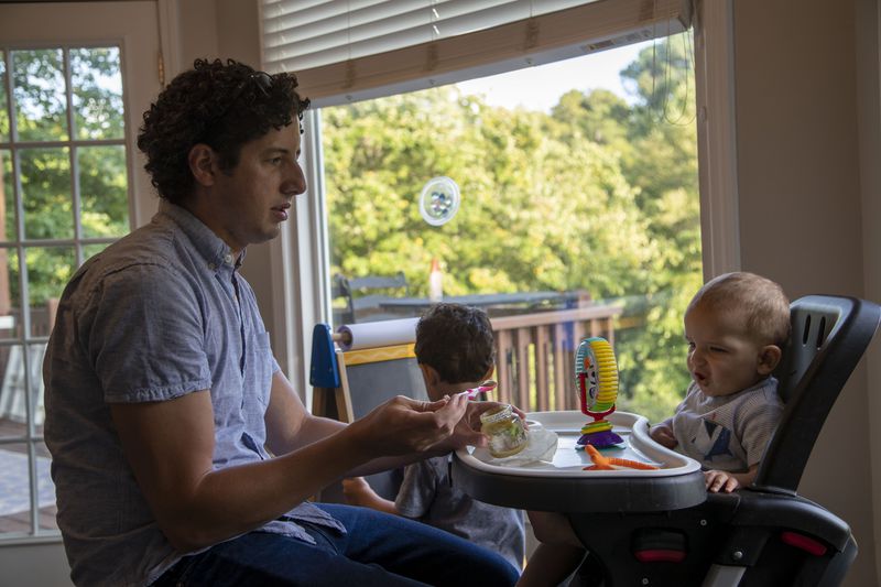 Tommy Beeson, husband of Democratic state Senate candidate Sarah Beeson, feeds their youngest son Rowan (right) during dinner time at their residence in Roswell on Sept. 10, 2020. Tommy helps Sarah by keeping the kids busy in the basement as she participates in campaign events in the evening. (Alyssa Pointer / Alyssa.Pointer@ajc.com)