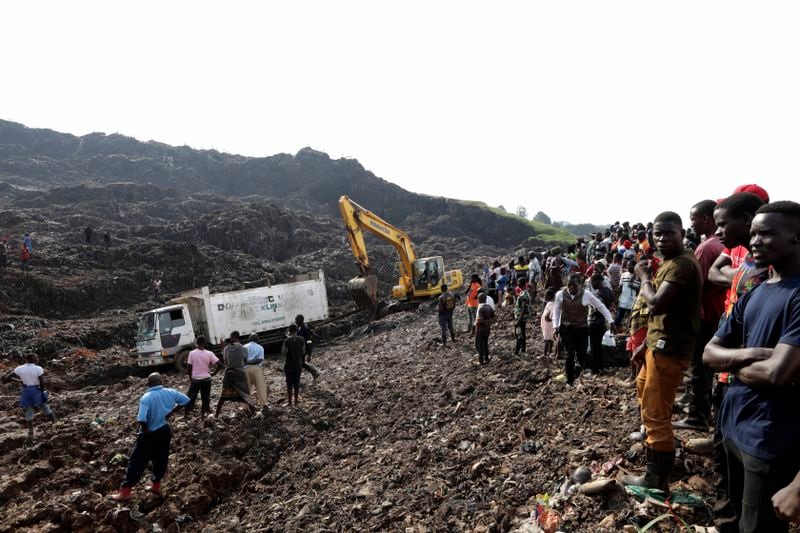 Onlookers watch as workers search for survivors at the site of a collapsed landfill in Kampala, Uganda, Sunday, Aug. 11, 2024. (AP Photo/Hajarah Nalwadda )